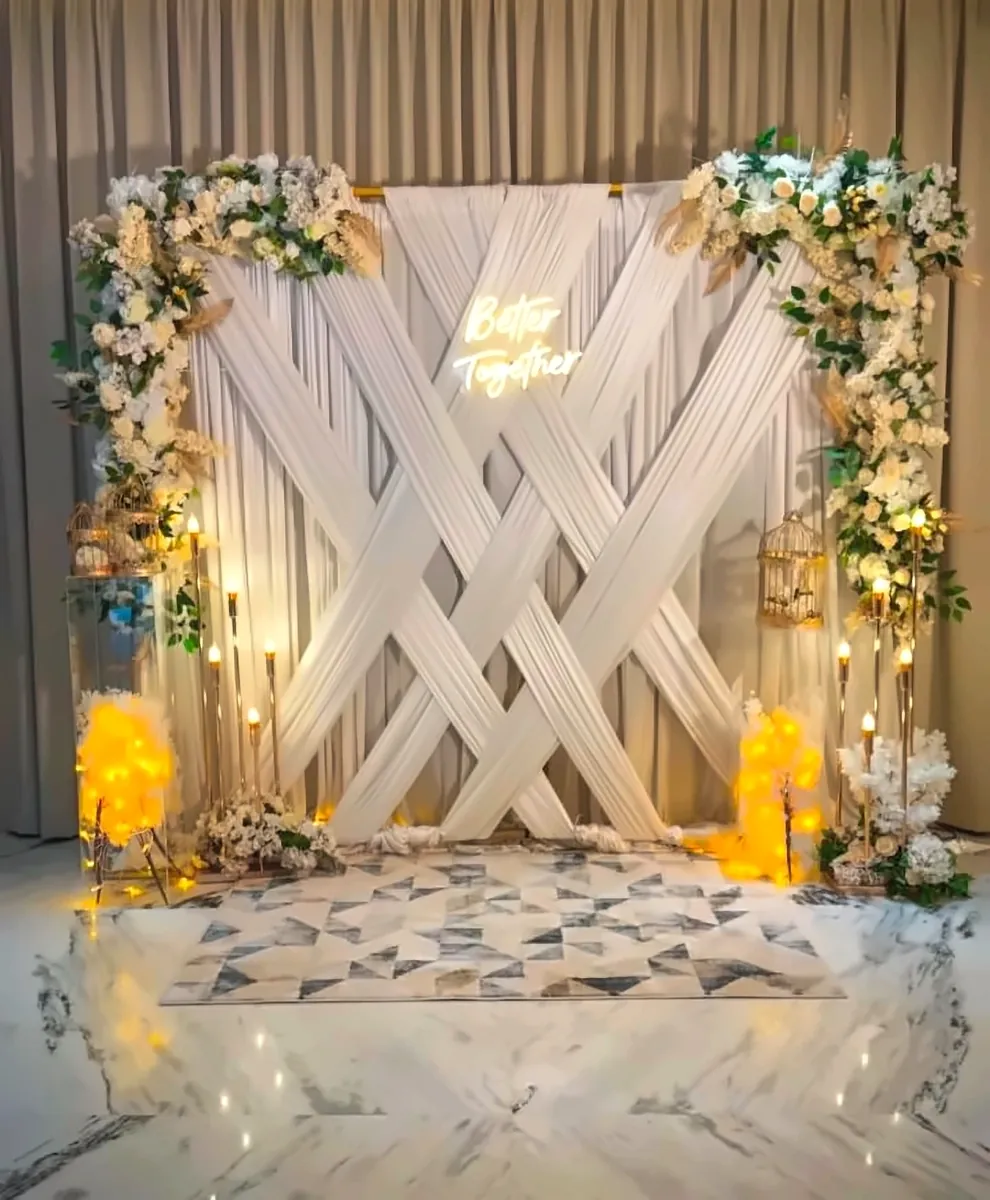 White criss-cross draped Better Together backdrop with flowers, candles and warm lights by Mayur Events Bilaspur