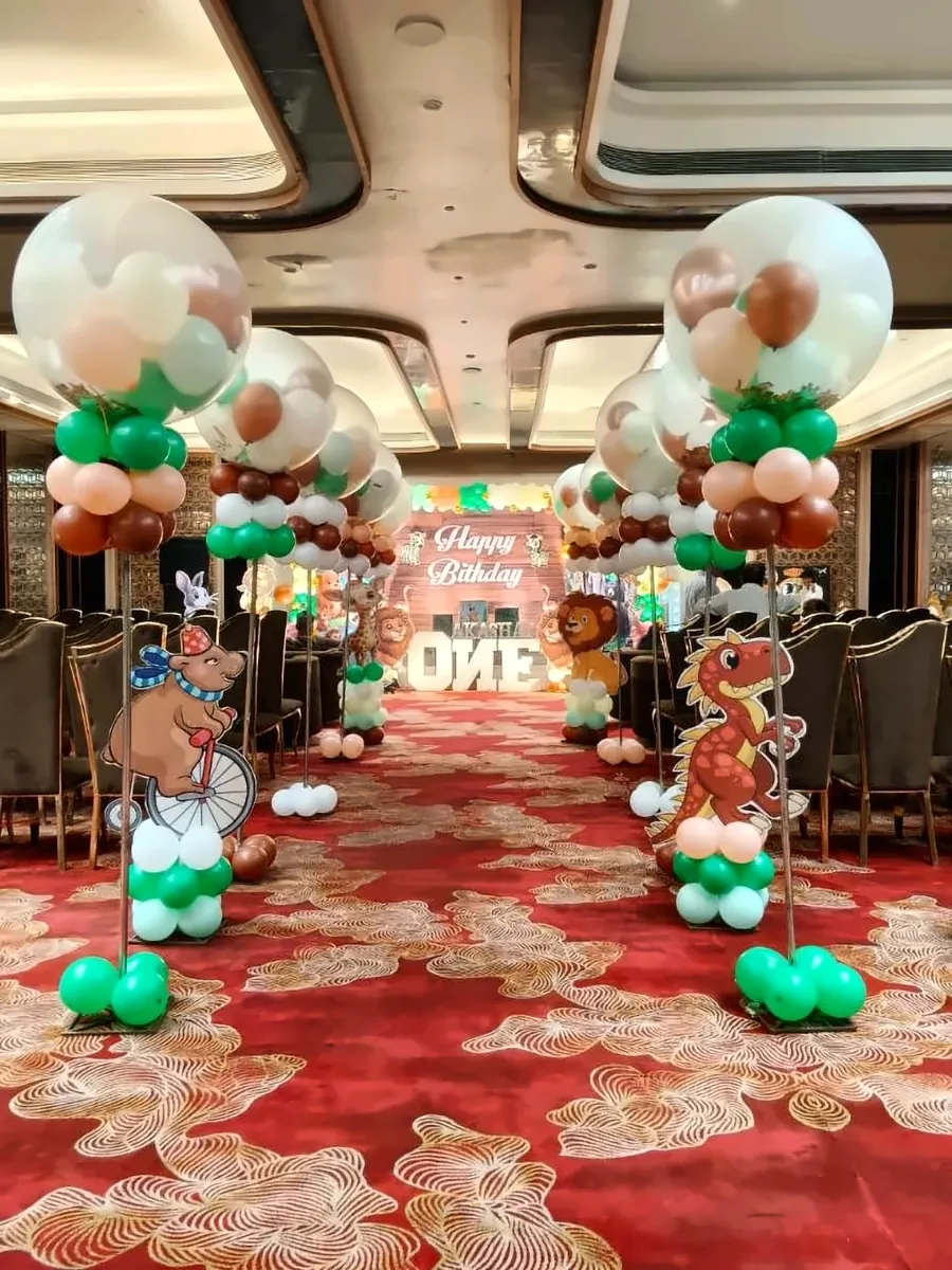 Jungle theme birthday balloon aisle with animal cut-outs and balloon pillars in a banquet hall by Mayur Events Bilaspur